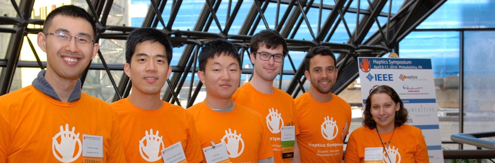 Smiling student volunteers welcome attendees